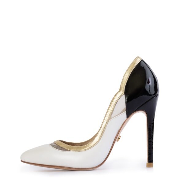 Side view of black and white heels with gold accents